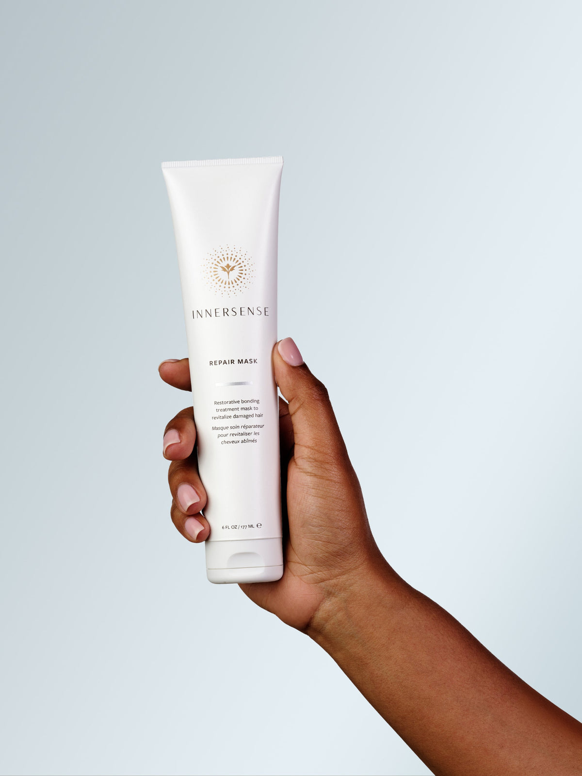 Hand holding INNERSENSE Repair Hair Mask for damaged and dry hair