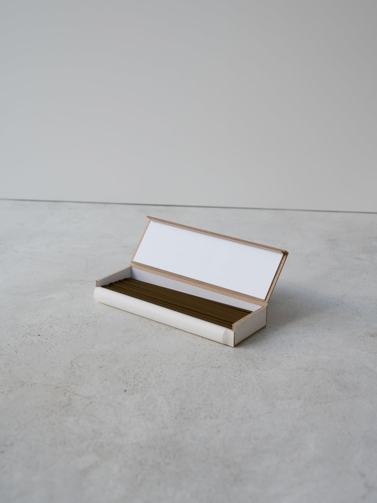 JJIMJIL Cypress Incense Sticks displayed in an open rectangular box on a light stone surface