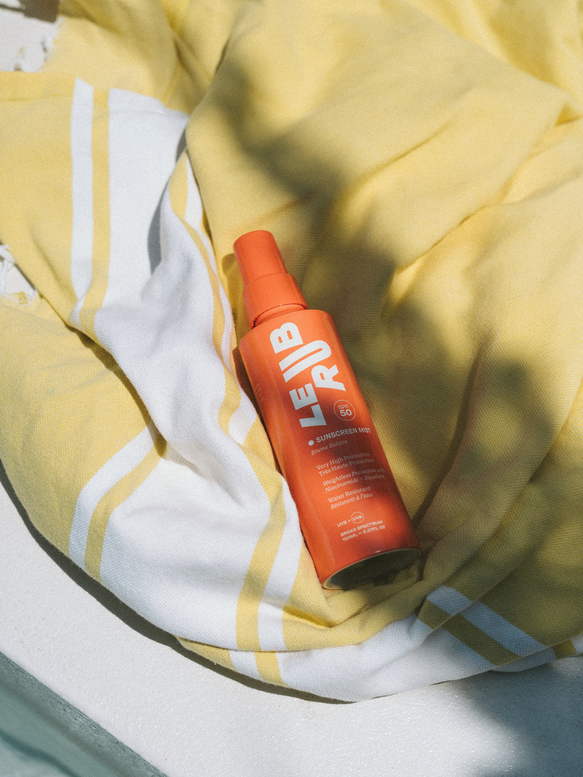 LE RUB Sunscreen Mist SPF 50 on a towel