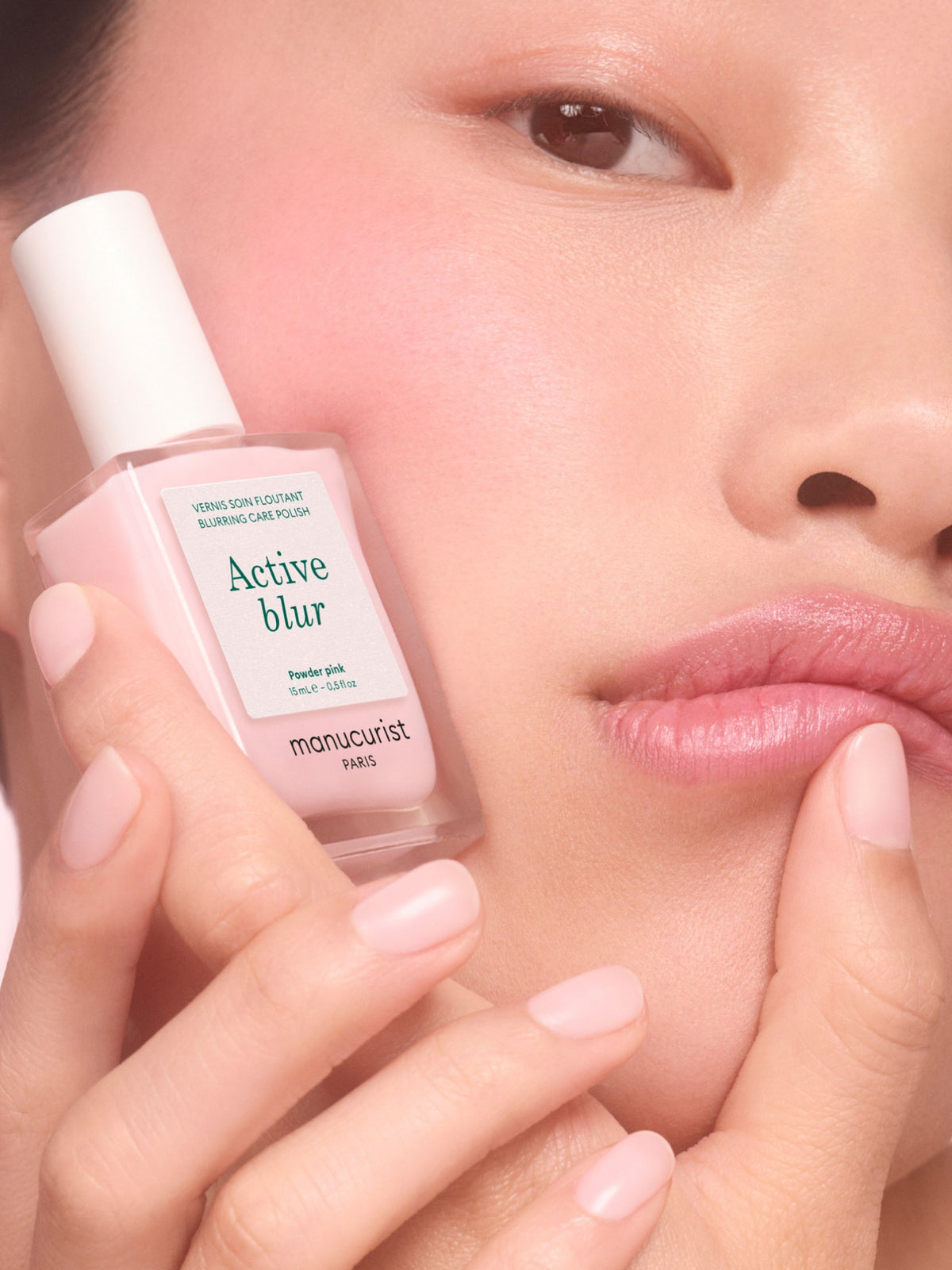 Model holding Manucurist Active Blur Powder Pink nail polish
