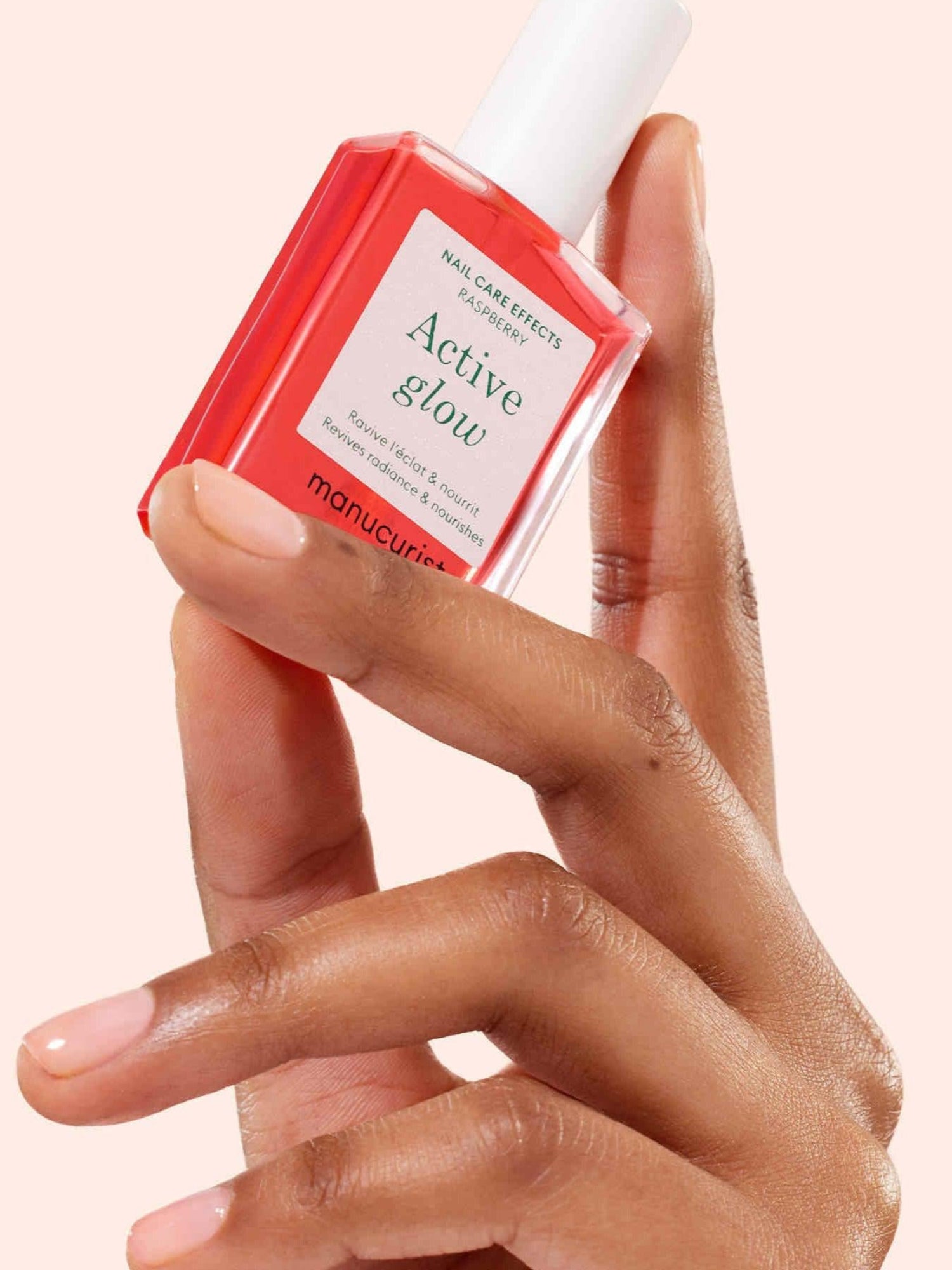 MANUCURIST Active Glow™ Raspberry nail care treatment held in hand
