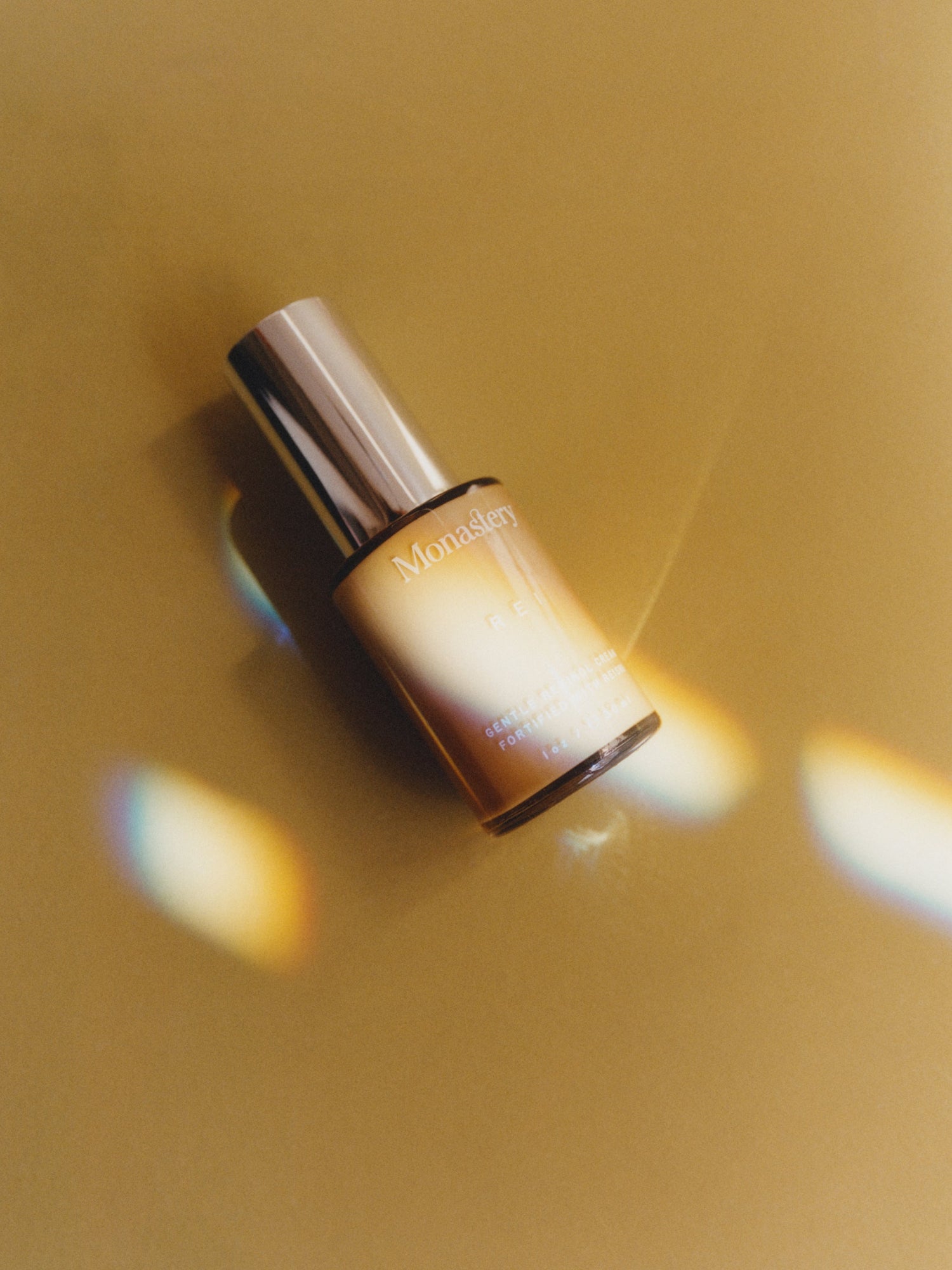 MONASTERY Rei Gentle Retinol Cream bottle in an artistic blue and gold still life