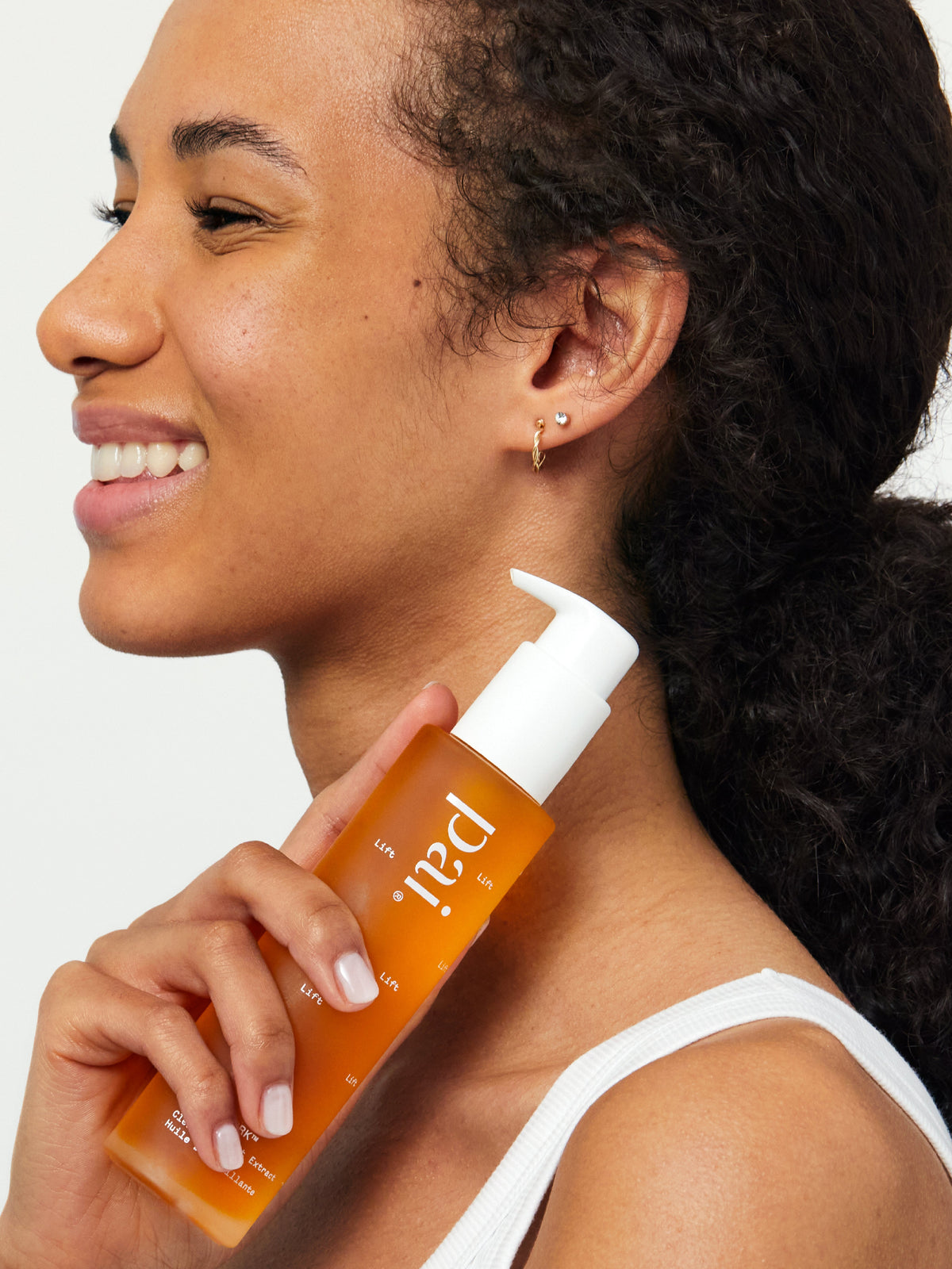 Model holding PAI Skincare Light Work Rosehip Fruit Extract Cleansing Oil