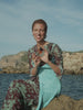VYRAO Free 00 Eau de Parfum held by a woman by the sea
