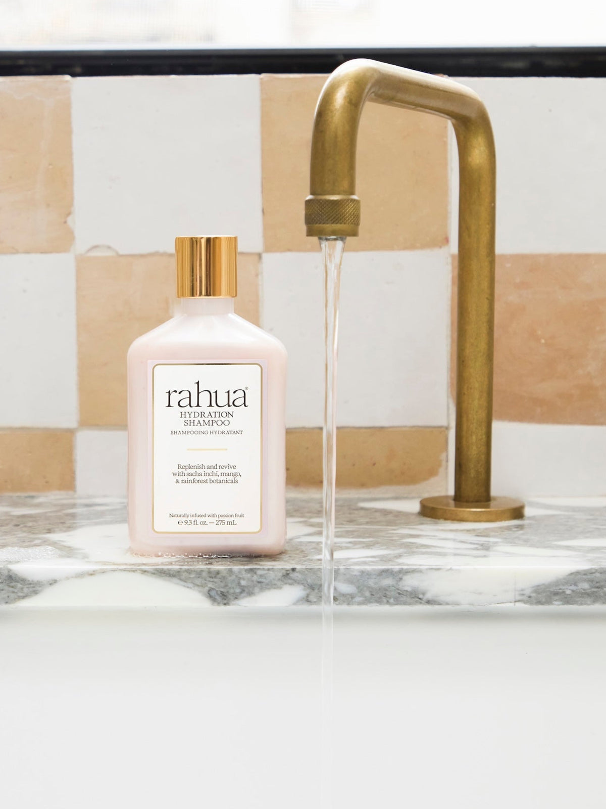 Rahua Hydration Shampoo 275 ml displayed beside a bathroom faucet