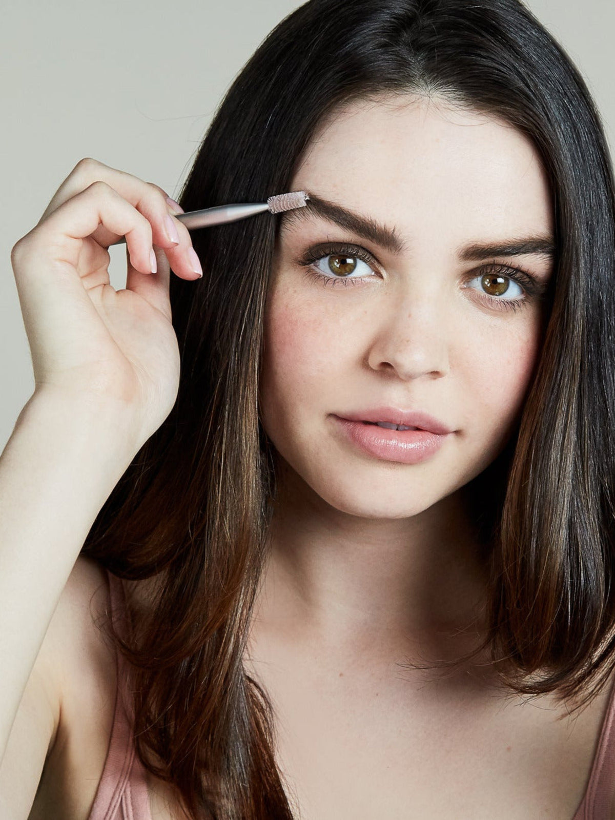 Model grooming her eyebrows with the RMS BEAUTY Back2Brow Brush