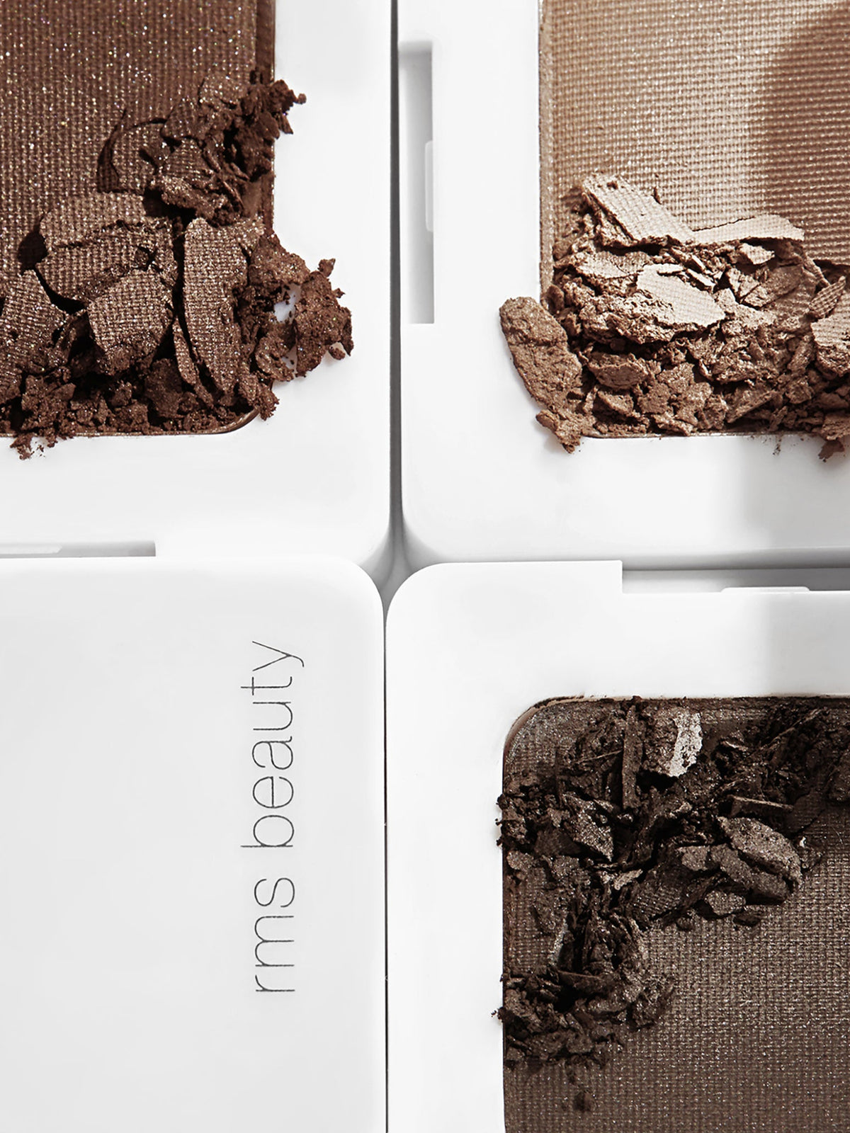 Close-up of RMS Beauty Back2Brow Powder in Dark with broken powder pieces showing its texture