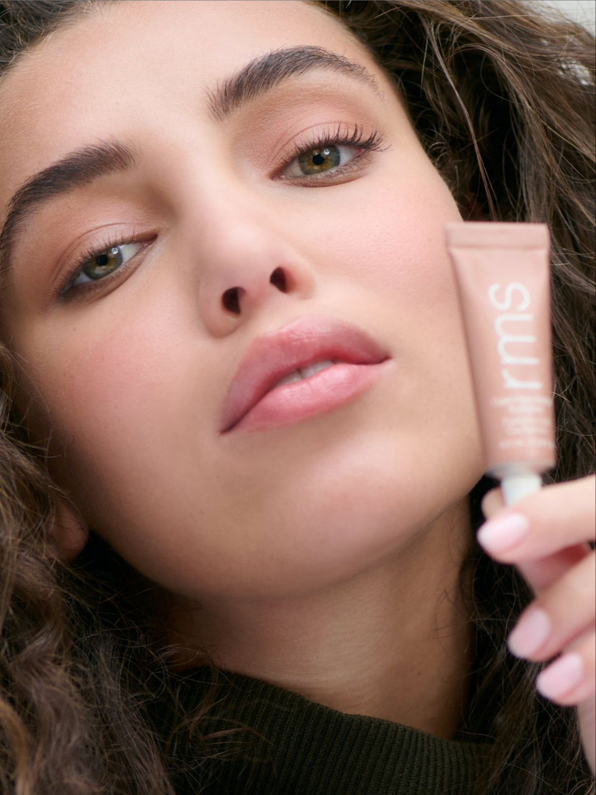 RMS BEAUTY Cashmere Matte Eyelights in Dusty Trail held by a model showcasing the warm peachy-brown eyeshadow shade
