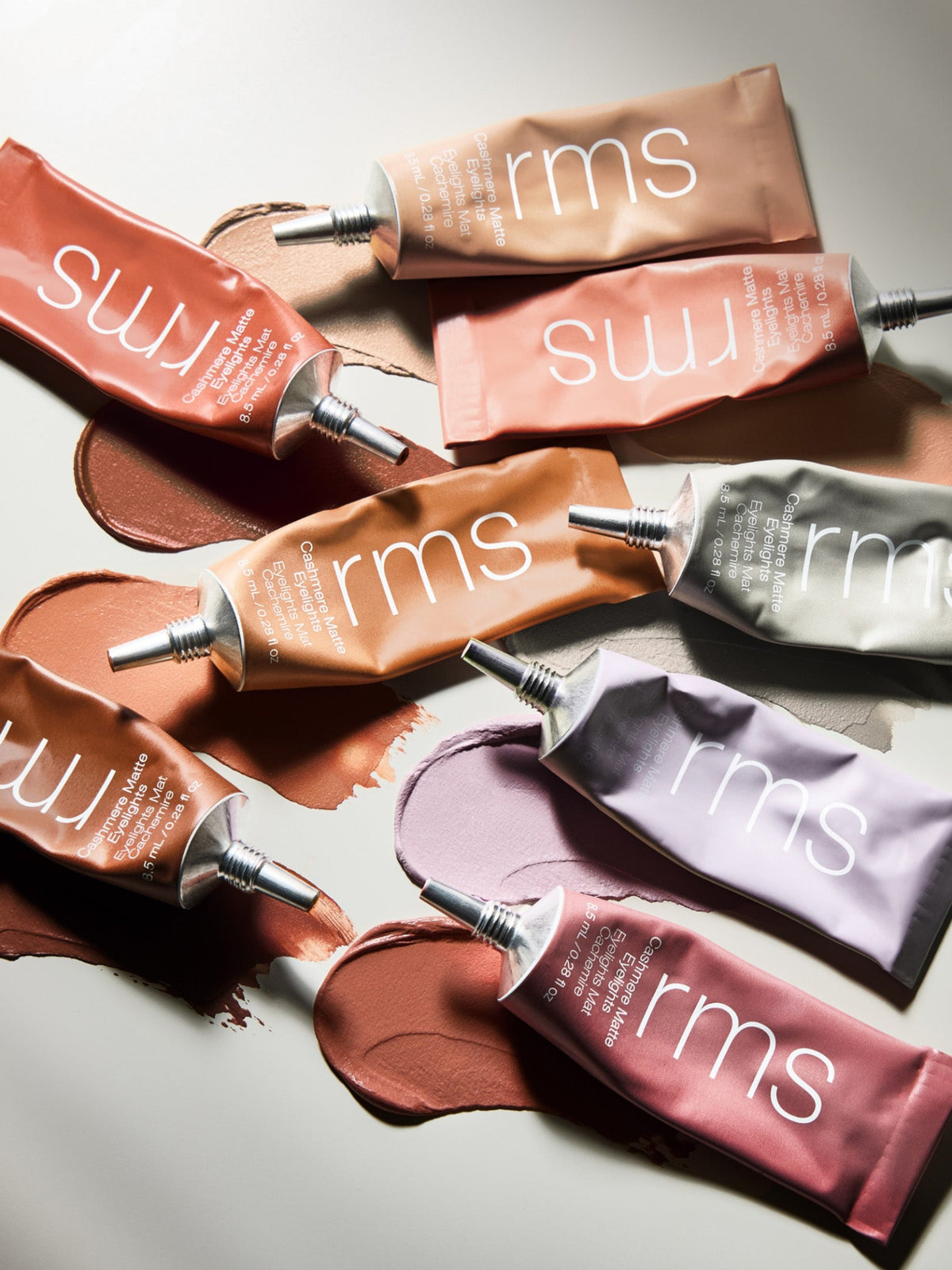 RMS Beauty Cashmere Matte Eyelights in multiple shades arranged with cream eyeshadow swatches
