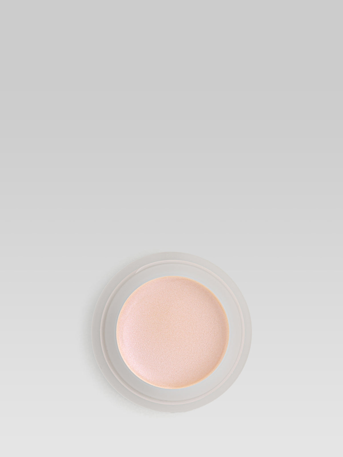 RMS Beauty Champagne Rose Luminizer, soft champagne-pink highlighting cream in a round compact, photographed from above on a light grey background
