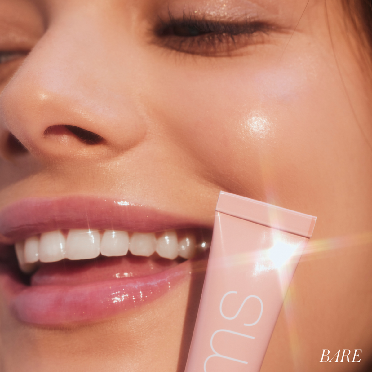 Model wearing RMS Beauty Lip Lights Cream Lip Gloss in Bare with glossy pink lips