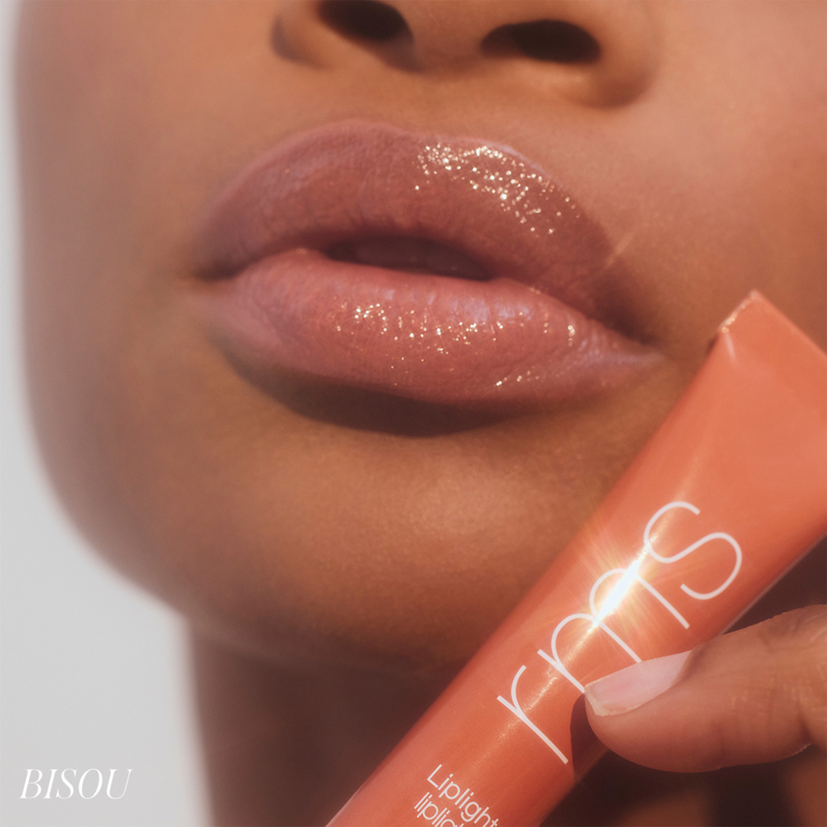 Close-up of a model wearing RMS Beauty Lip Lights Cream Lip Gloss in Bisou, showing glossy terracotta-toned lips