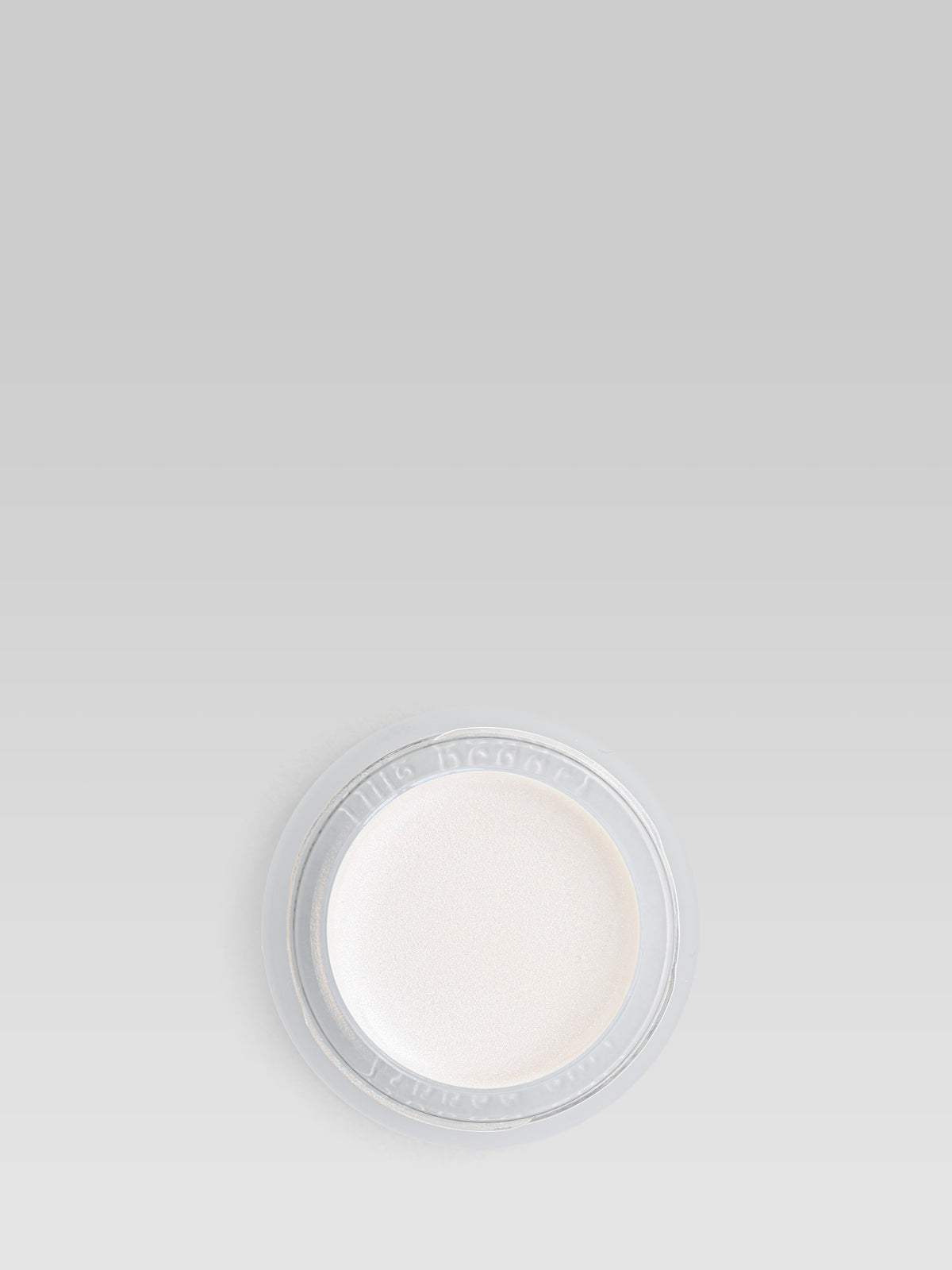 RMS Beauty Living Luminizer in an open round pot, showing its pearlescent ivory highlighting cream against a light grey background