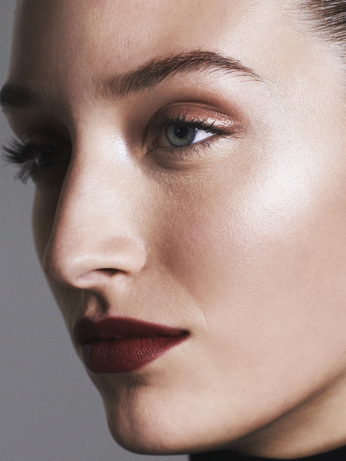 Model wearing a luminous makeup look with softly highlighted skin and defined lips