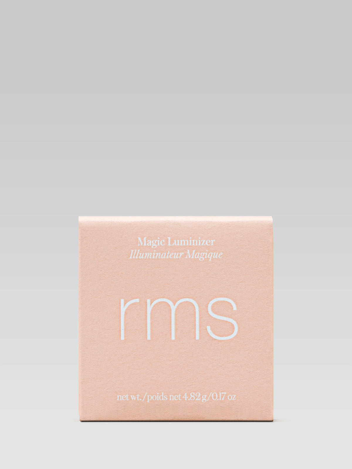 RMS Beauty Magic Luminizer in a peach-toned outer carton with white lettering, photographed against a light background