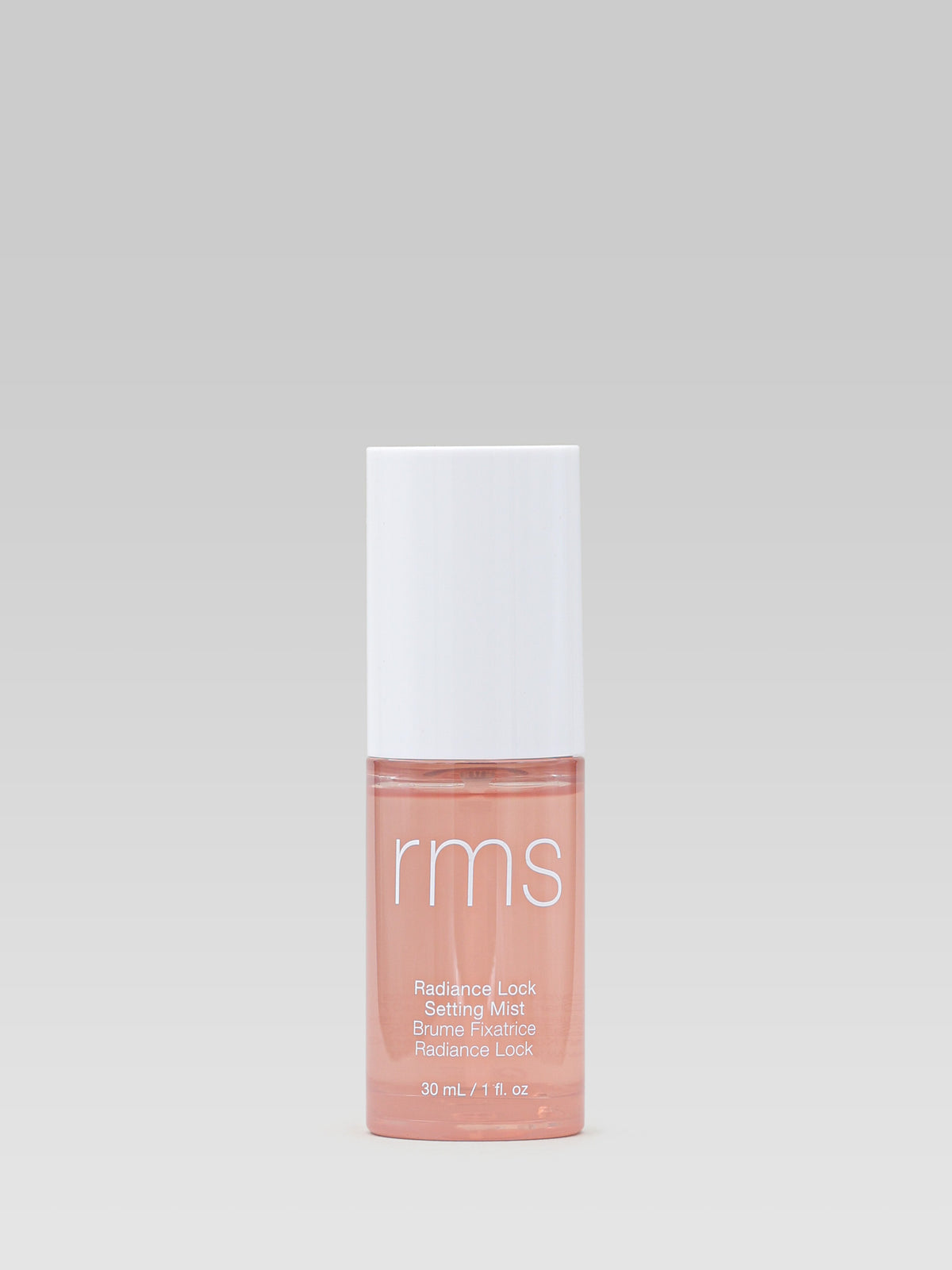 RMS Beauty Radiance Lock Setting Mist travel size 30 ml bottle with a white cap against a light grey background