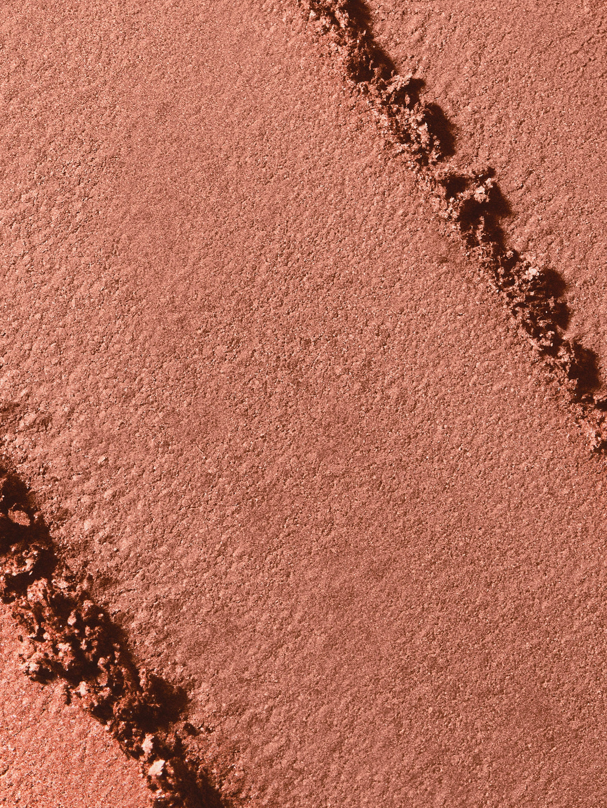 Close-up of the silky, warm bronze powder texture of RMS Beauty ReDimension Hydra Bronzer in Beachwalk Betty