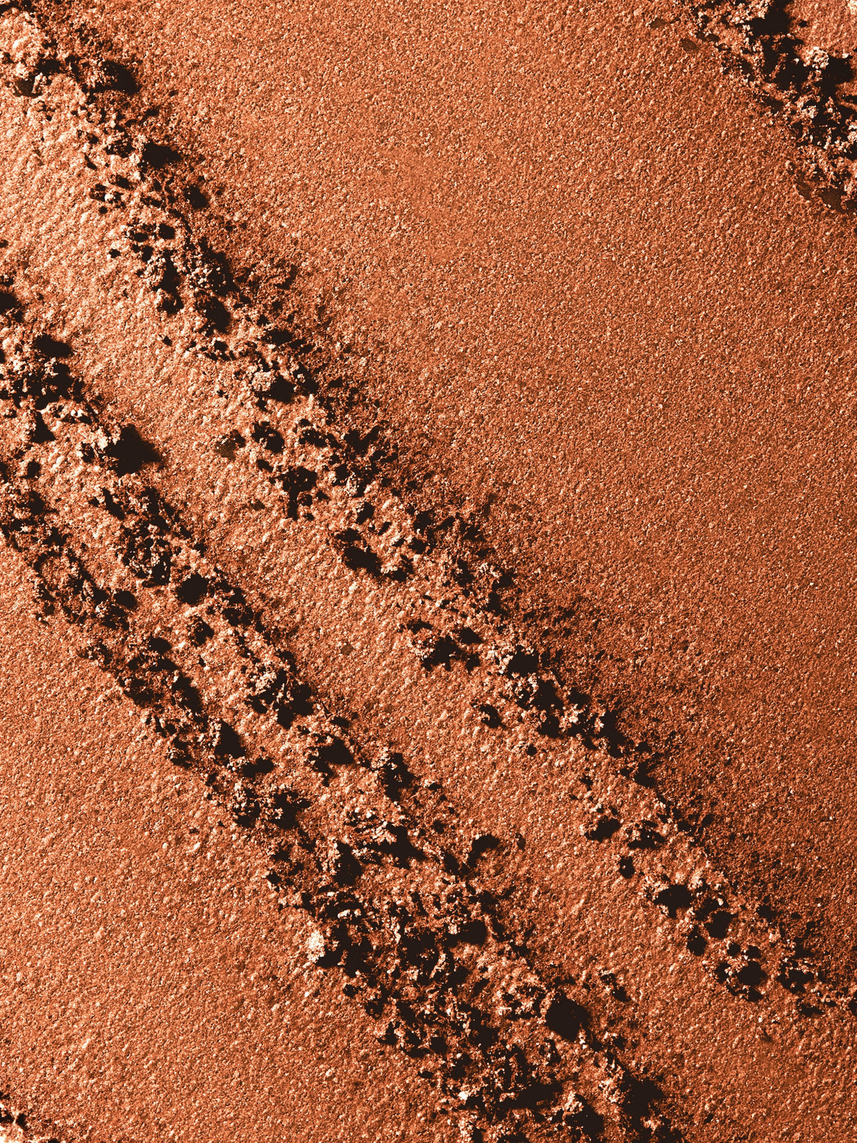 Close-up swatch of RMS Beauty ReDimension Hydra Bronzer in Malibu Muse showing its warm bronze shade and luminous finish.