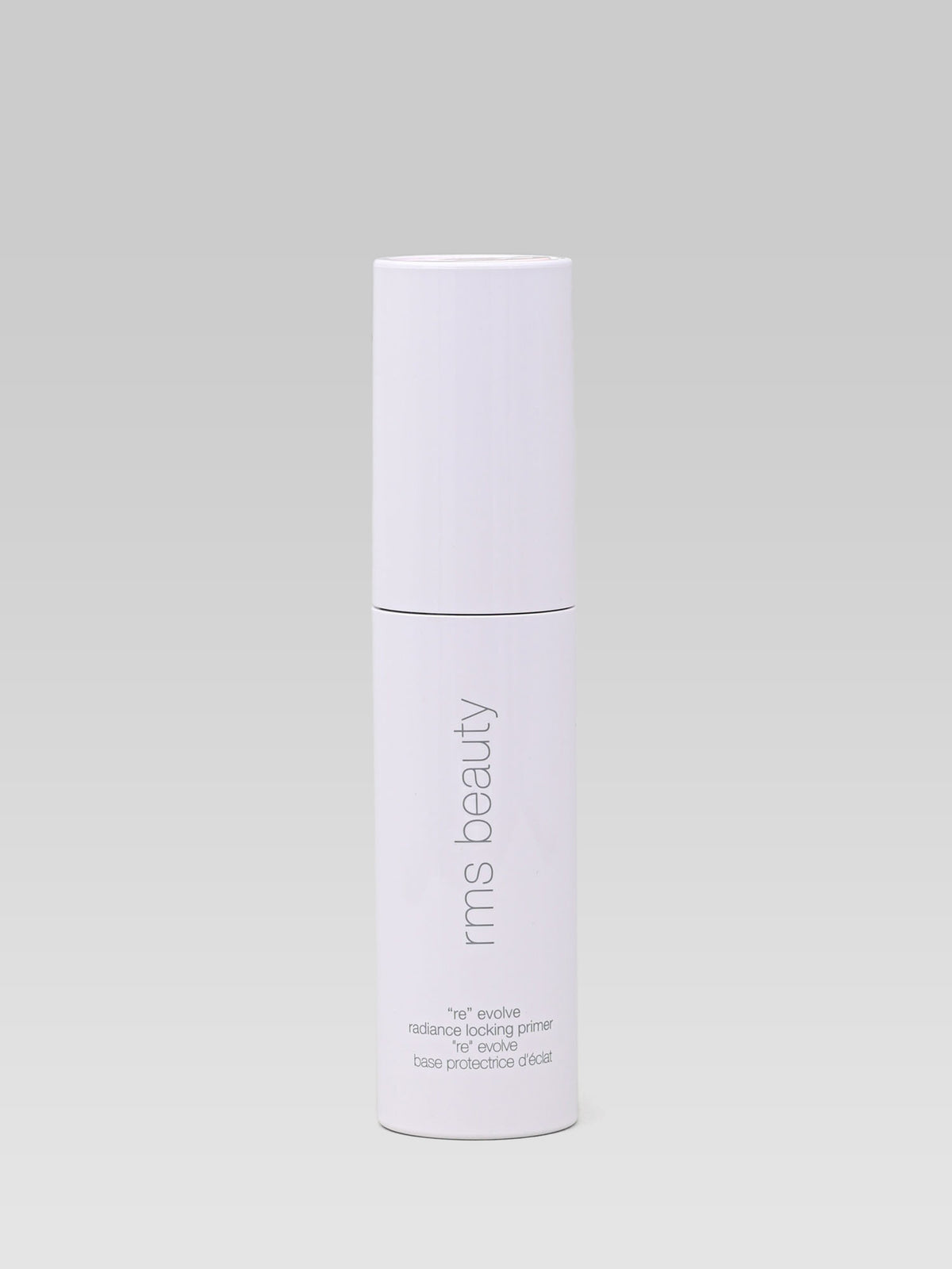 RMS Beauty ReEvolve Radiance Locking Primer in a white bottle with a subtle pink tint, photographed against a light background