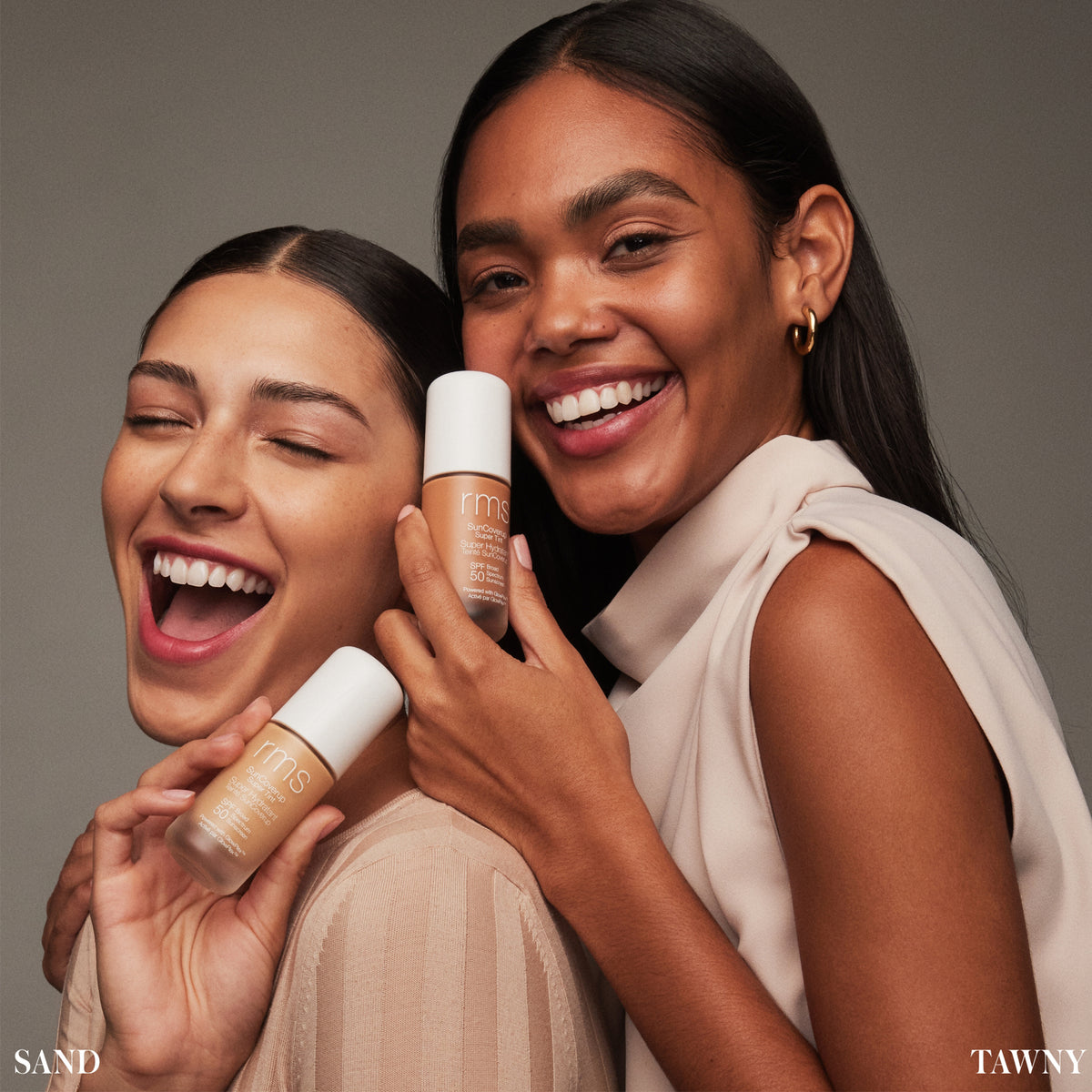 Models holding RMS Beauty SunCoverup Super Tint SPF 50 in Sand and Tawny, showcasing two shades of the tinted moisturiser