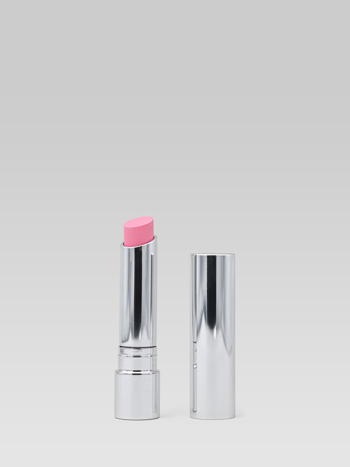 RMS Beauty Tinted Daily Lip Balm in Destiny Lane, pink tinted lip balm in silver packaging with cap displayed beside the open tube