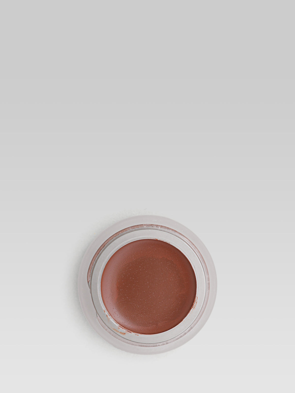 RMS Beauty UnCoverup Concealer in shade 111, shown in an open round pot with a deep, warm reddish-brown cream concealer against a light grey background.