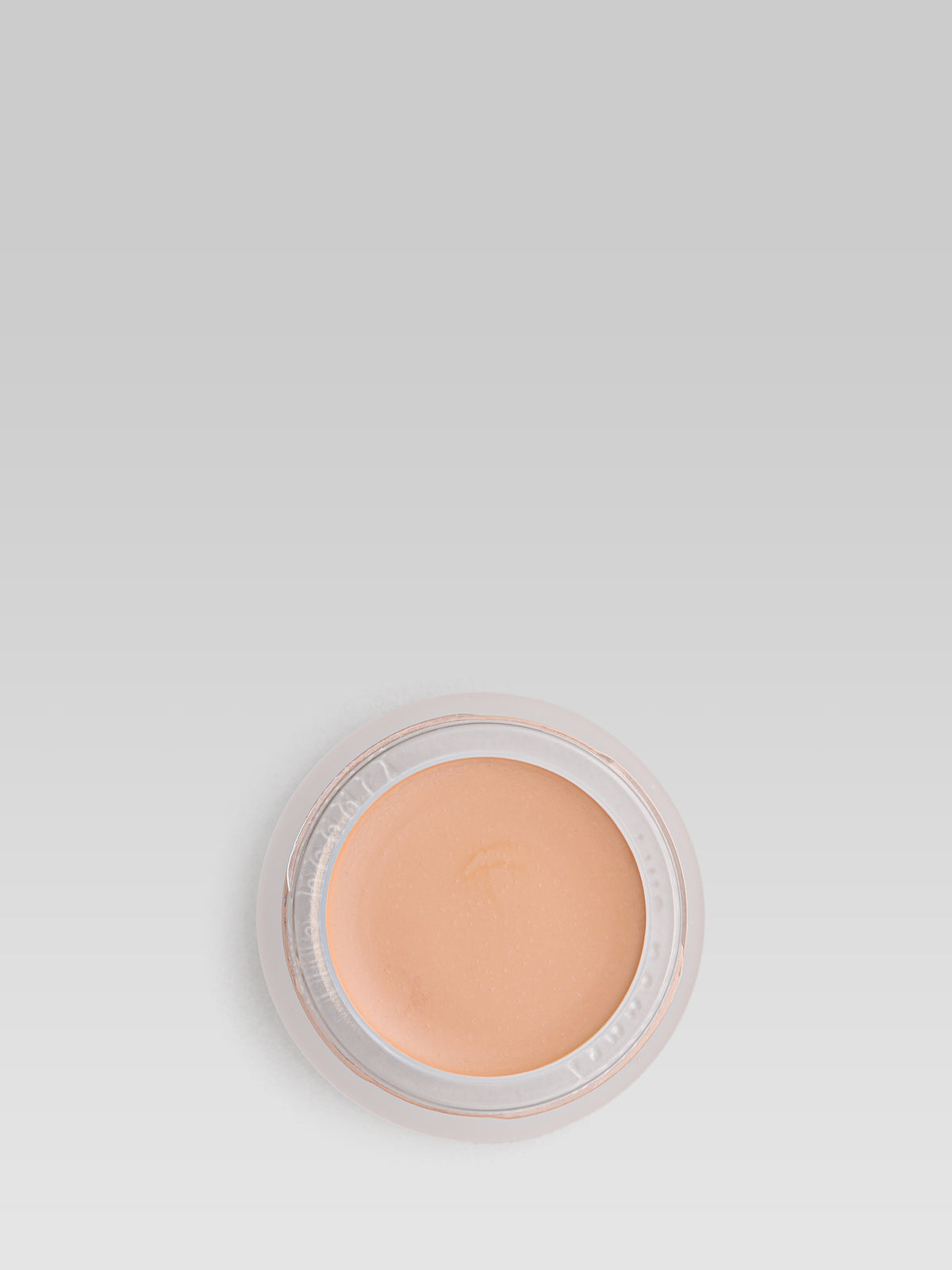 RMS Beauty UnCoverup Concealer in shade 33.5, shown in an open round pot with a warm peach-beige cream concealer against a light grey background