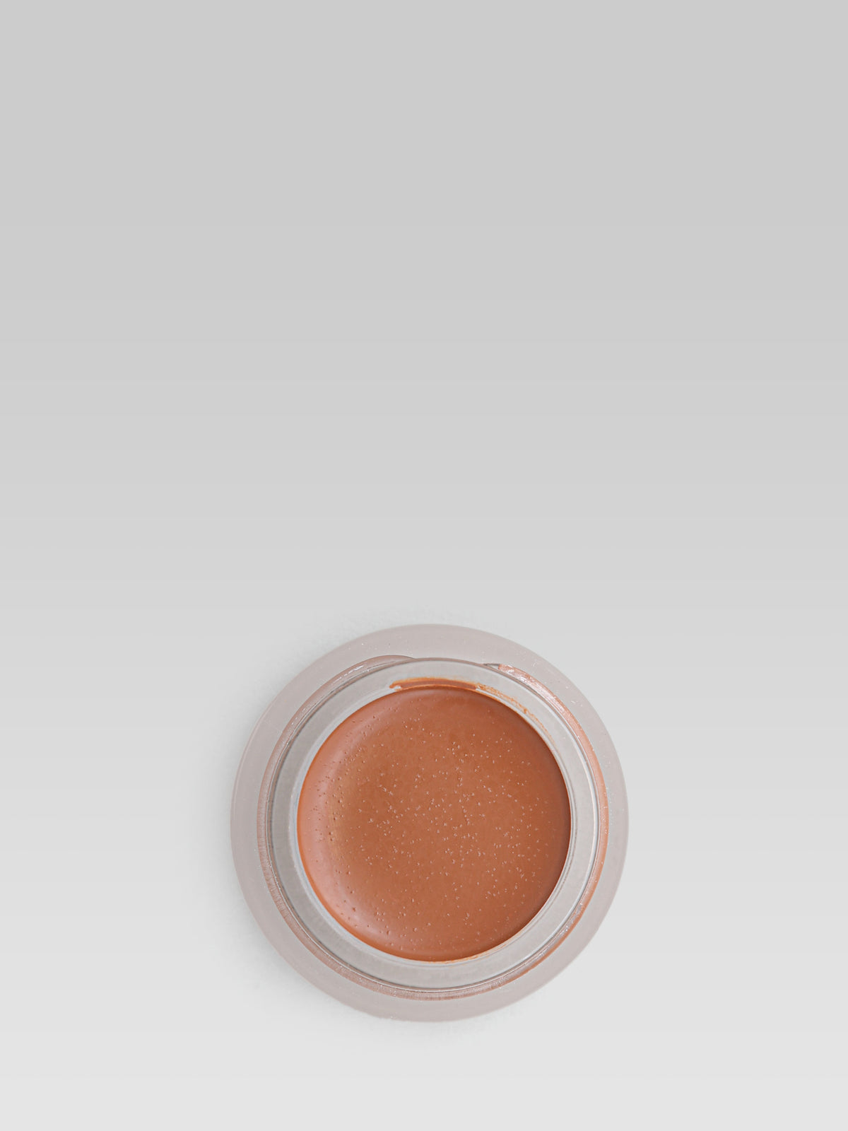 RMS Beauty UnCoverup Concealer in shade 77, shown in an open round pot with a warm deep terracotta-brown cream concealer against a light grey background