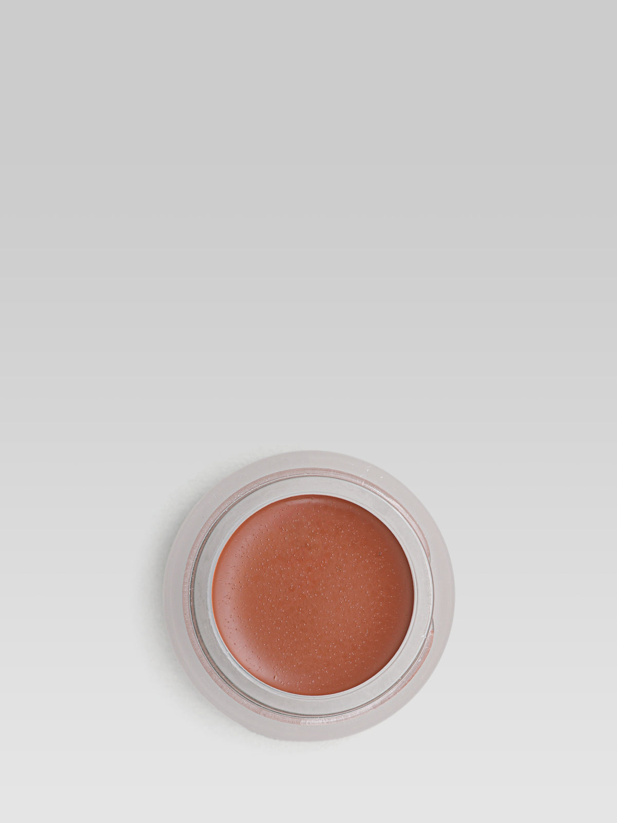 RMS Beauty UnCoverup Concealer in shade 99, shown in an open round pot with a warm, deep reddish-brown cream concealer against a light grey background.