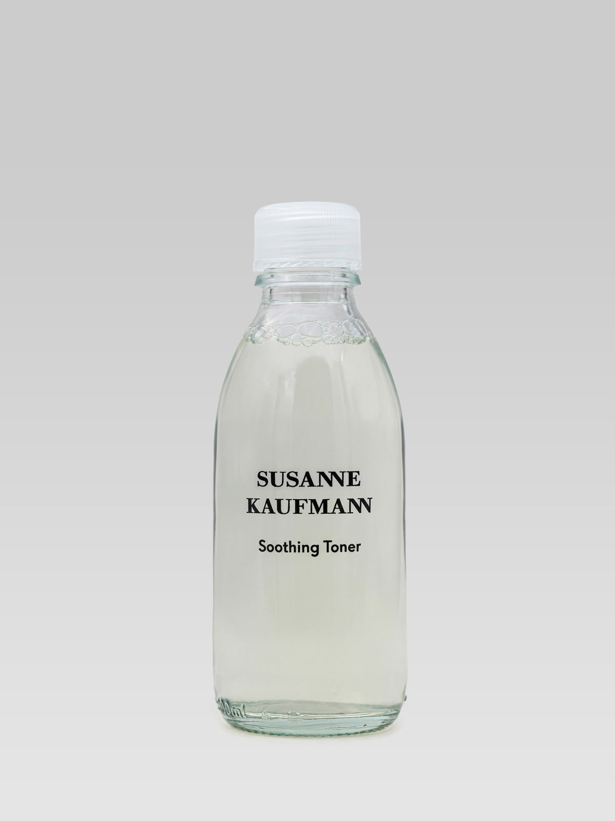 Susanne Kaufmann Soothing Toner in a clear glass bottle with a white cap.