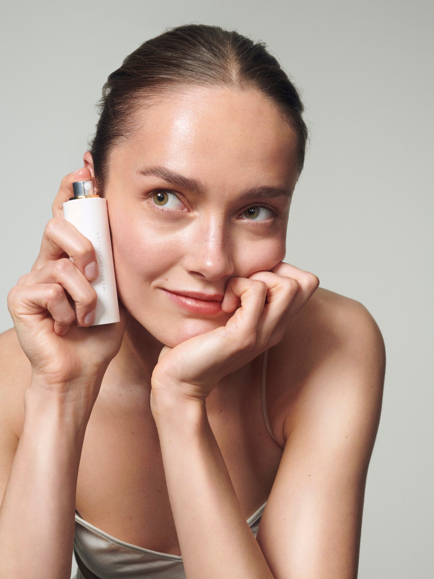 Woman applying Westman Atelier Skin Activator serum to her face